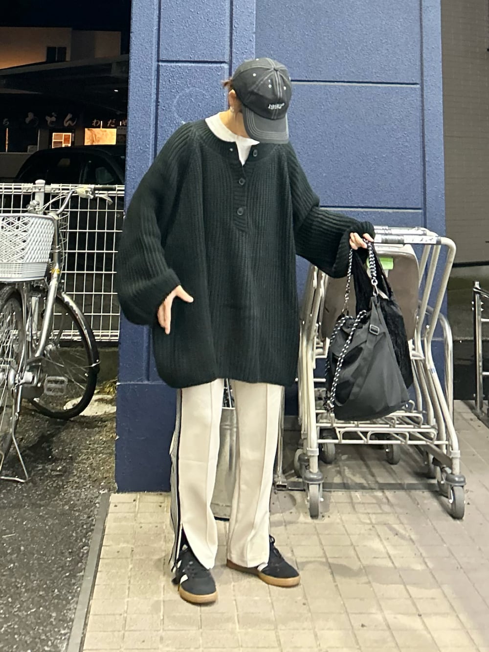 ブラック系のニット/セーター、ベージュ系のスウェットパンツ、ブラック系のトートバッグを着用したレディースの秋コーディネートの2枚目の写真