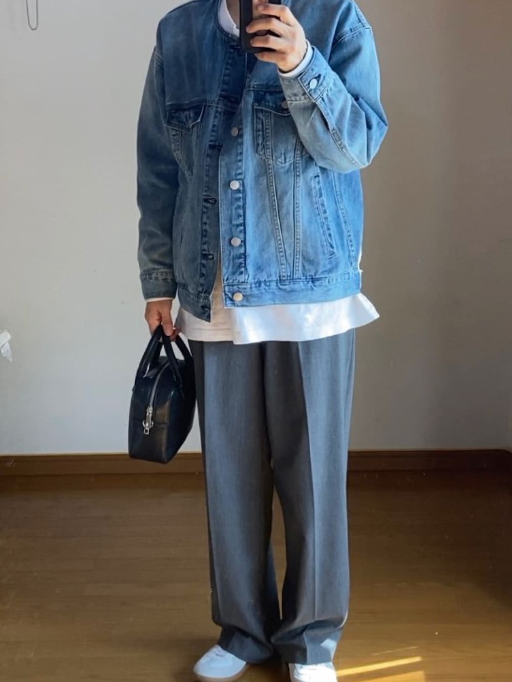 ブルー系のデニムジャケット、グレー系のスラックス、ホワイト系のスニーカーを着用したキッズの秋コーディネートの2枚目の写真