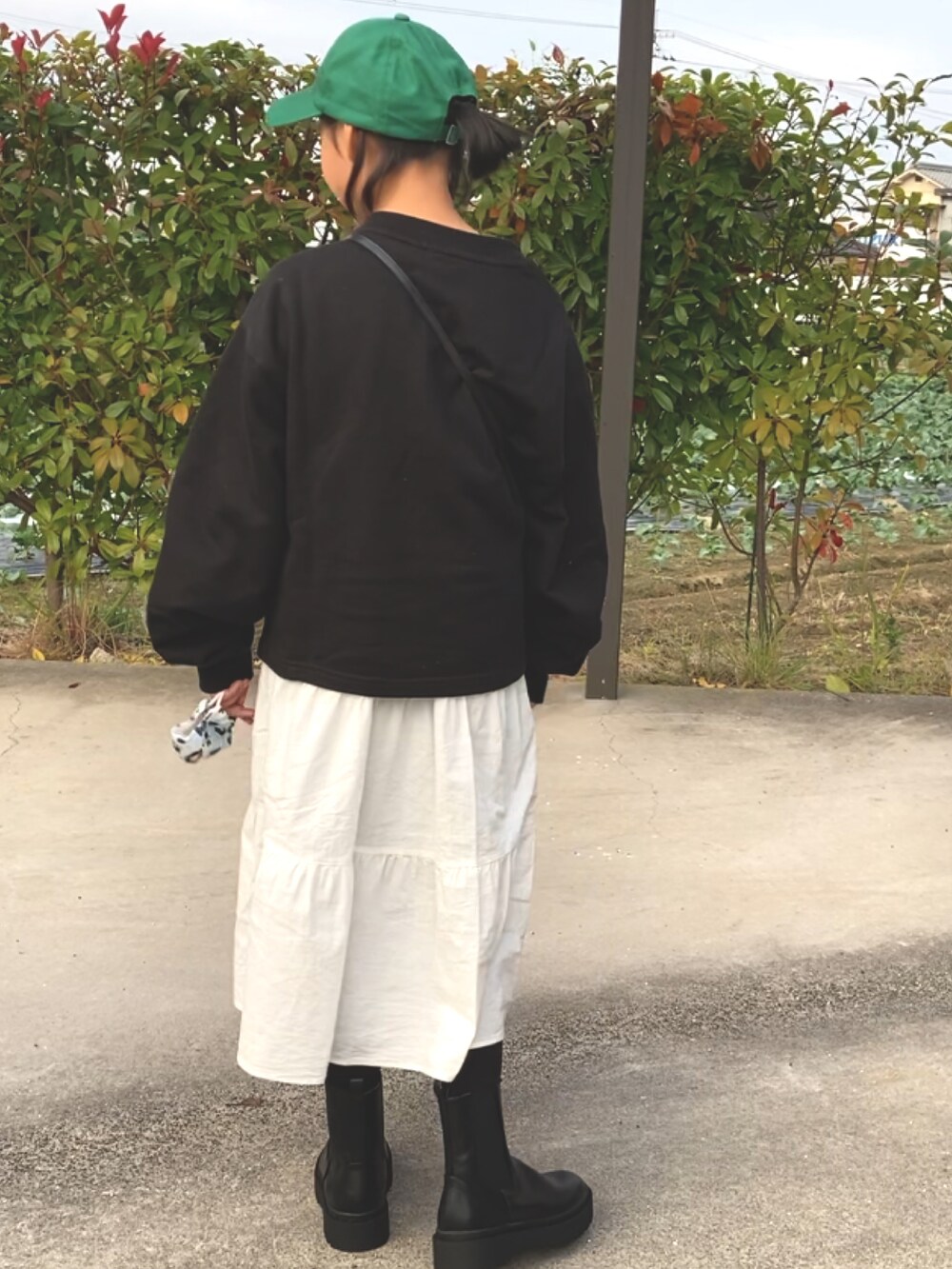 ブラック系のスウェット、ホワイト系のワンピース、ブラック系のブーツを着用したキッズの秋コーディネートの2枚目の写真