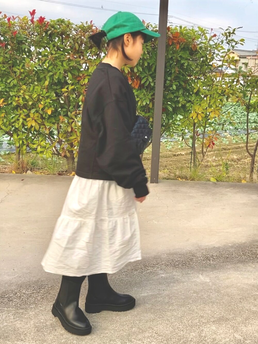 ブラック系のスウェット、ホワイト系のワンピース、ブラック系のブーツを着用したキッズの秋コーディネートの3枚目の写真