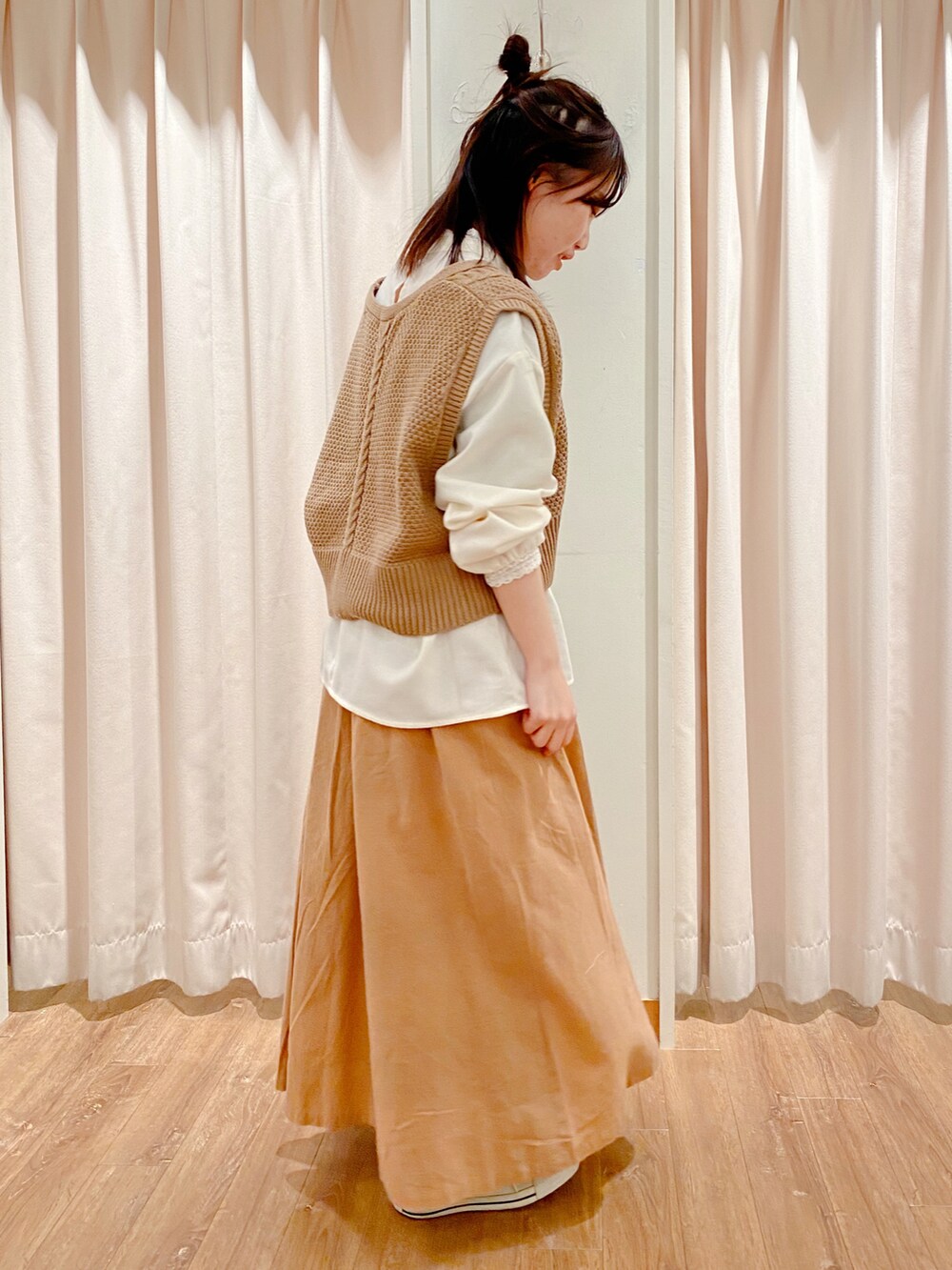 ブラック系のスニーカー、ベージュ系のスカート、ホワイト系のシャツ/ブラウスを着用したレディースの冬コーディネートの3枚目の写真