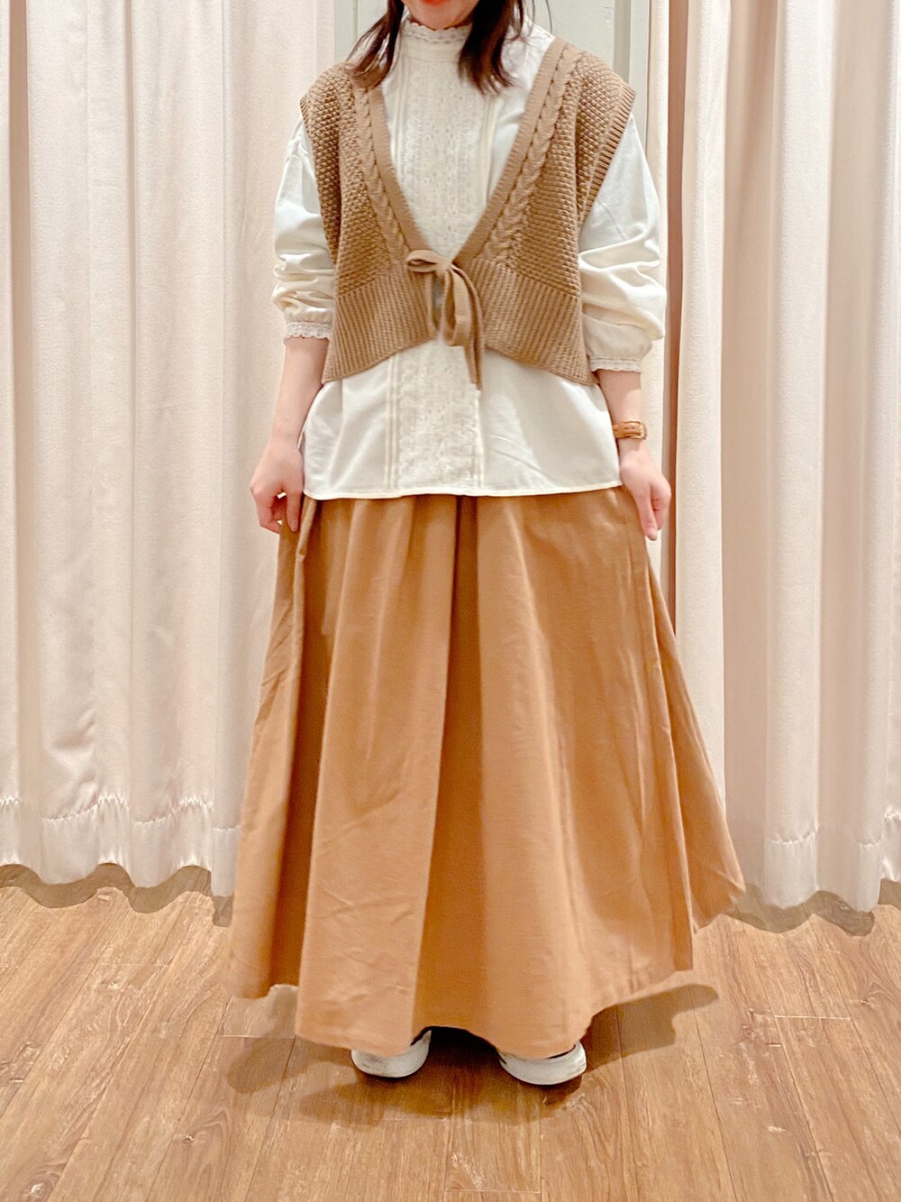 ブラック系のスニーカー、ベージュ系のスカート、ホワイト系のシャツ/ブラウスを着用したレディースの冬コーディネートの2枚目の写真