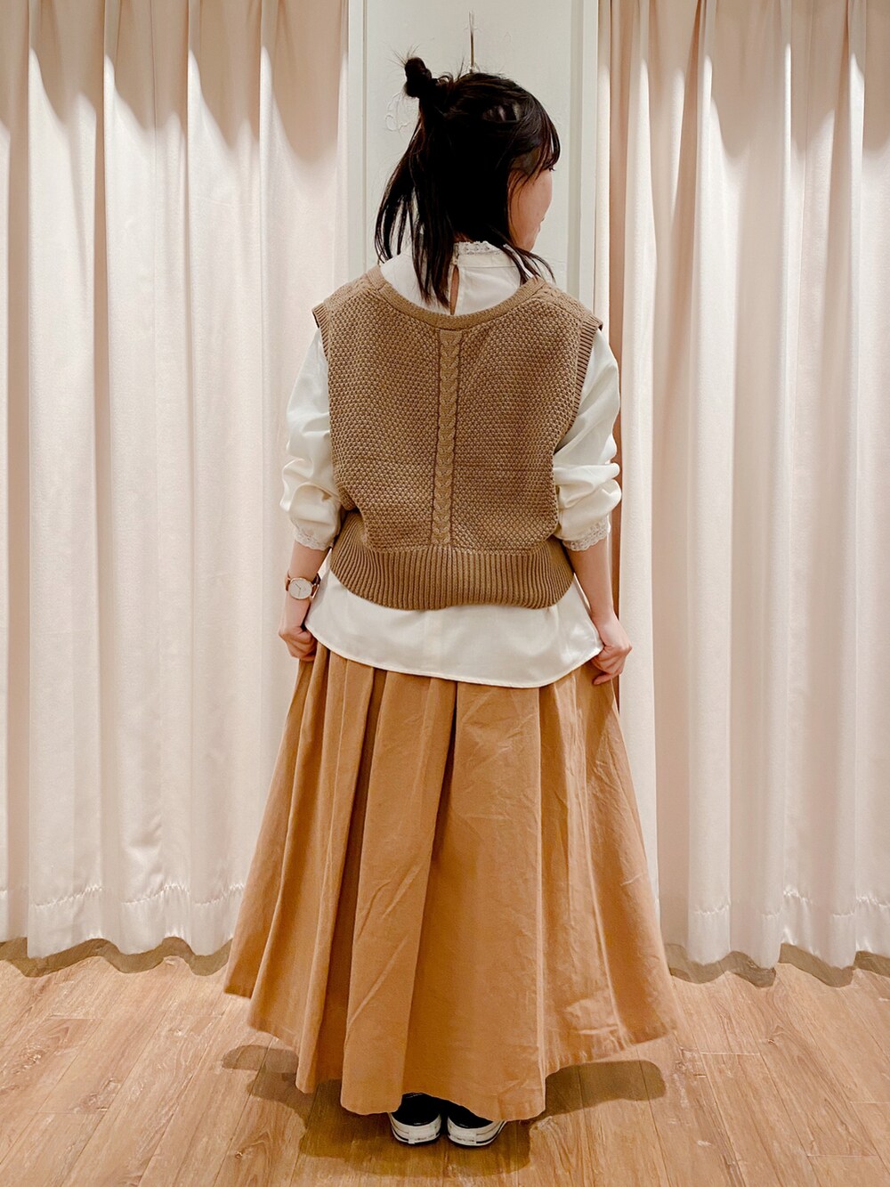 ブラック系のスニーカー、ベージュ系のスカート、ホワイト系のシャツ/ブラウスを着用したレディースの冬コーディネートの4枚目の写真