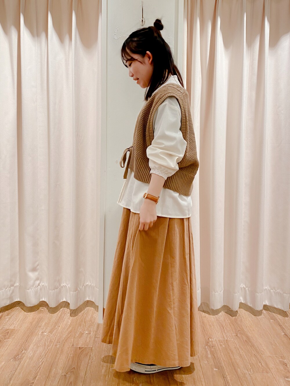 ブラック系のスニーカー、ベージュ系のスカート、ホワイト系のシャツ/ブラウスを着用したレディースの冬コーディネートの5枚目の写真