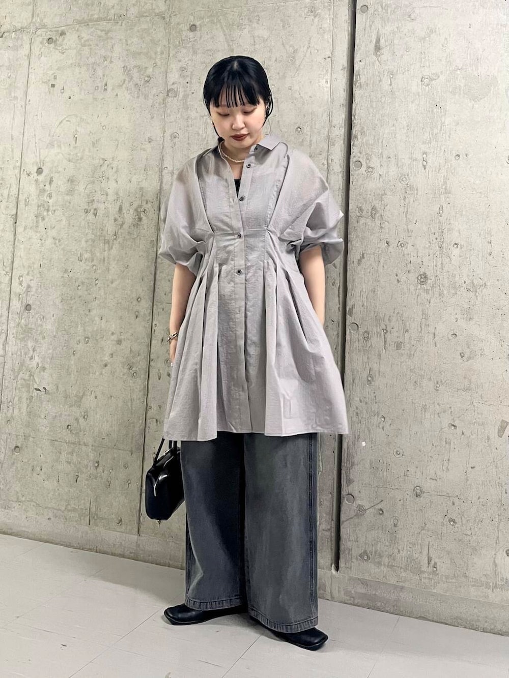 ブラック系のバレエシューズ、ブラック系のショルダーバッグ、ブラック系のデニムパンツを着用したレディースの夏コーディネートの2枚目の写真