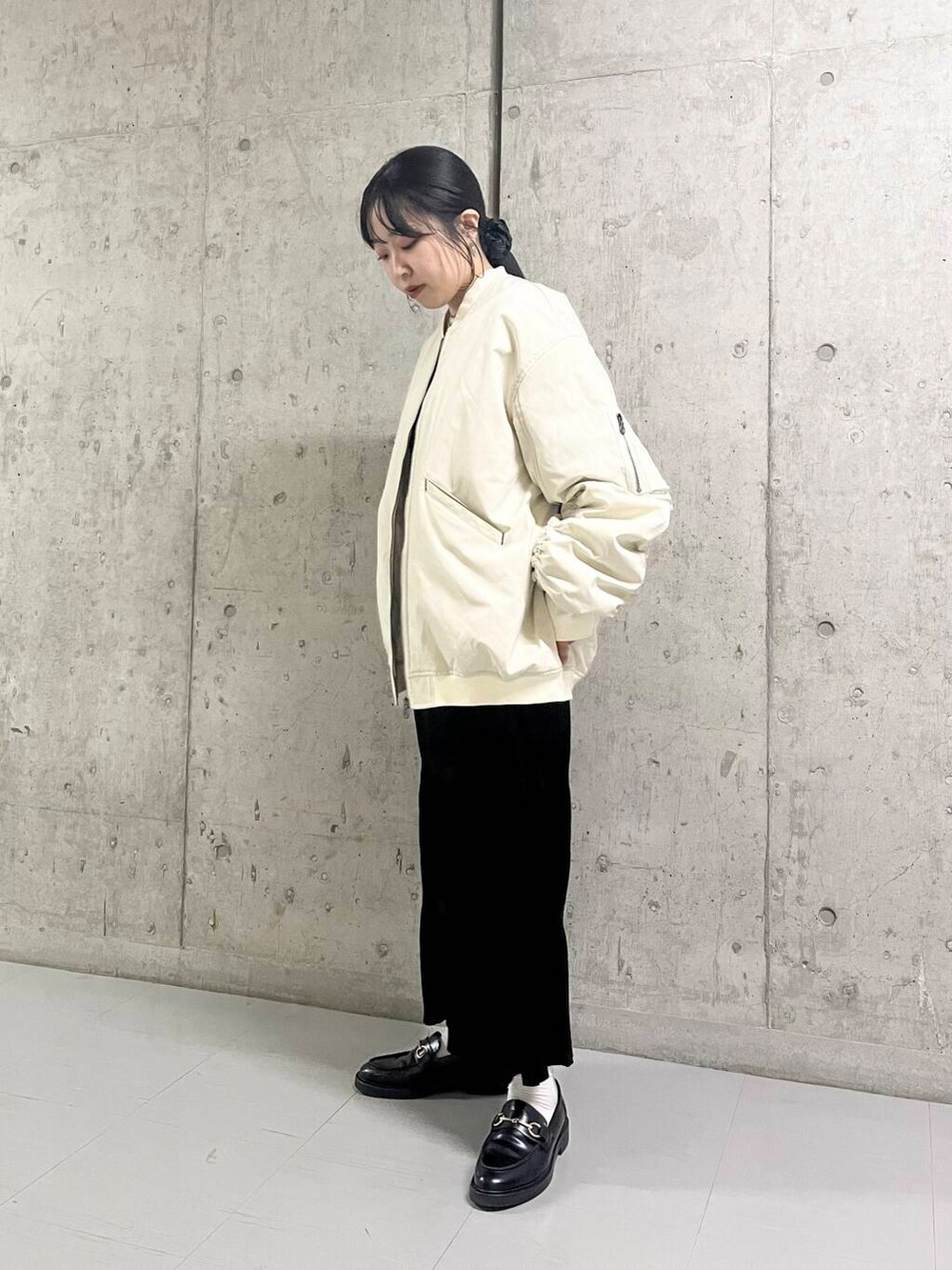 ホワイト系のMA-1、ブラック系のワンピースを着用したレディースの秋コーディネートの3枚目の写真