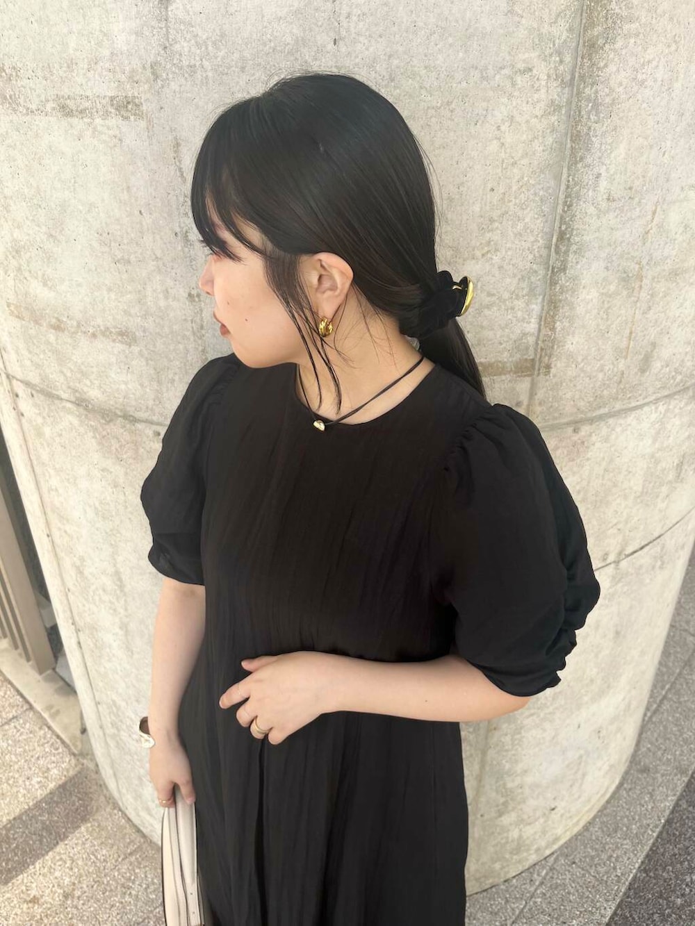 ブルー系のデニムパンツ、ベージュ系のハンドバッグ、ブラック系のバレエシューズを着用したレディースの春コーディネートの4枚目の写真