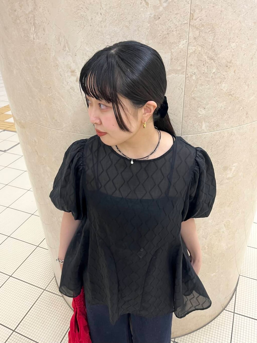 ブラック系のバレエシューズ、ブルー系のデニムパンツ、レッド系のショルダーバッグを着用したレディースの夏コーディネートの5枚目の写真