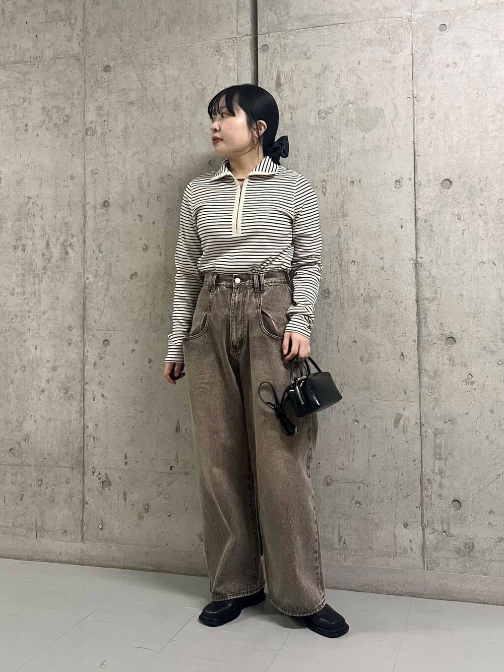 ブラック系のブーツ、ブラウン系のその他アウター、ブラウン系のデニムパンツを着用したレディースの冬コーディネートの5枚目の写真