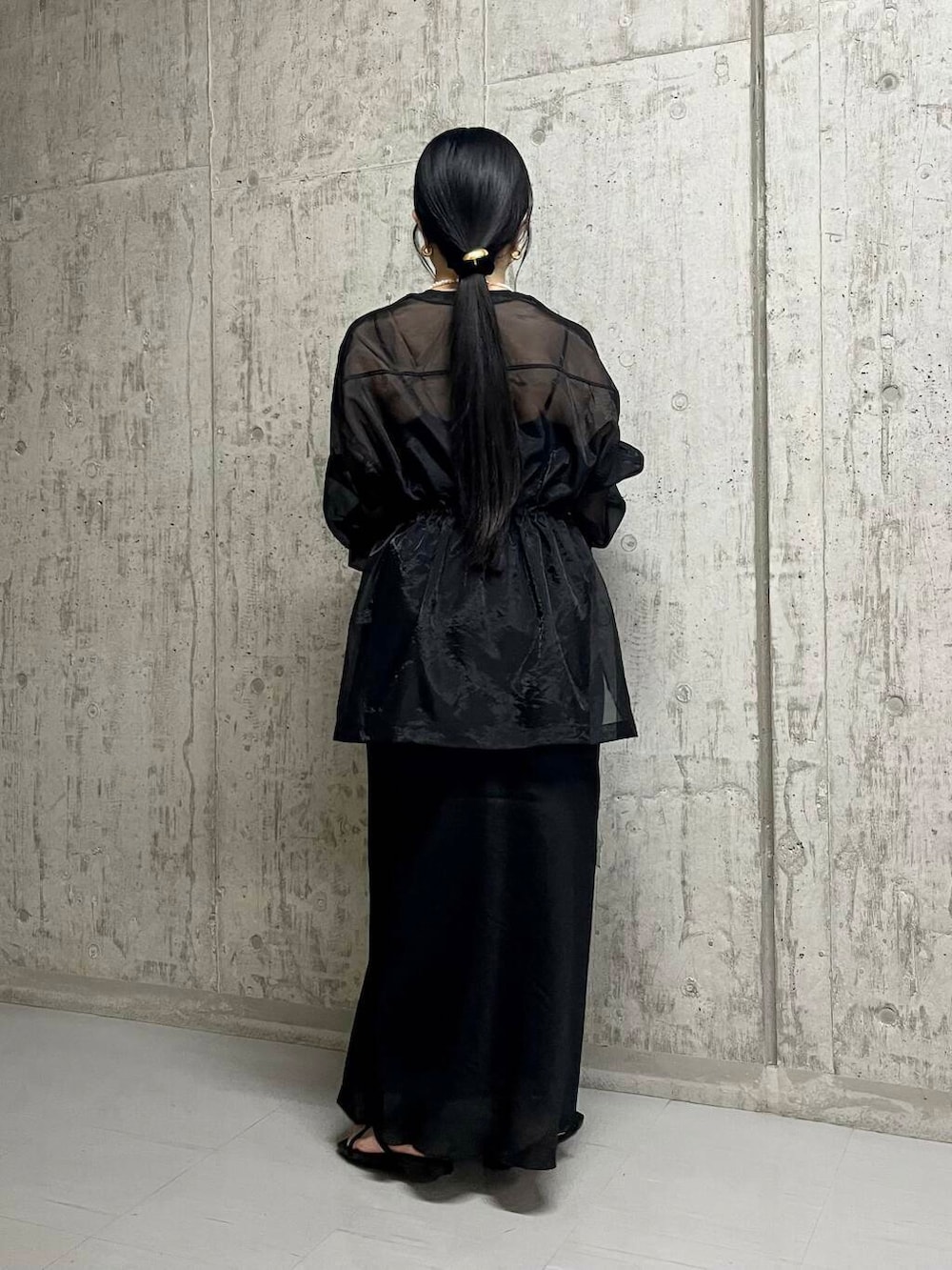 シルバー系のショルダーバッグ、ブラック系のスカート、ブラック系のサンダルを着用したレディースの夏コーディネートの3枚目の写真