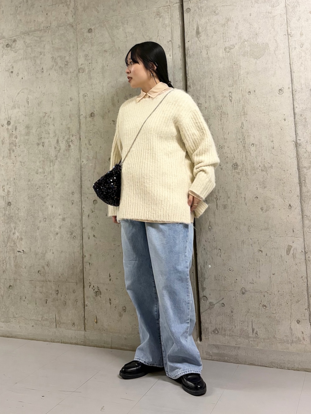 ホワイト系のニット/セーター、ベージュ系のシャツ/ブラウス、ブラック系のショルダーバッグを着用したレディースの冬コーディネートの2枚目の写真