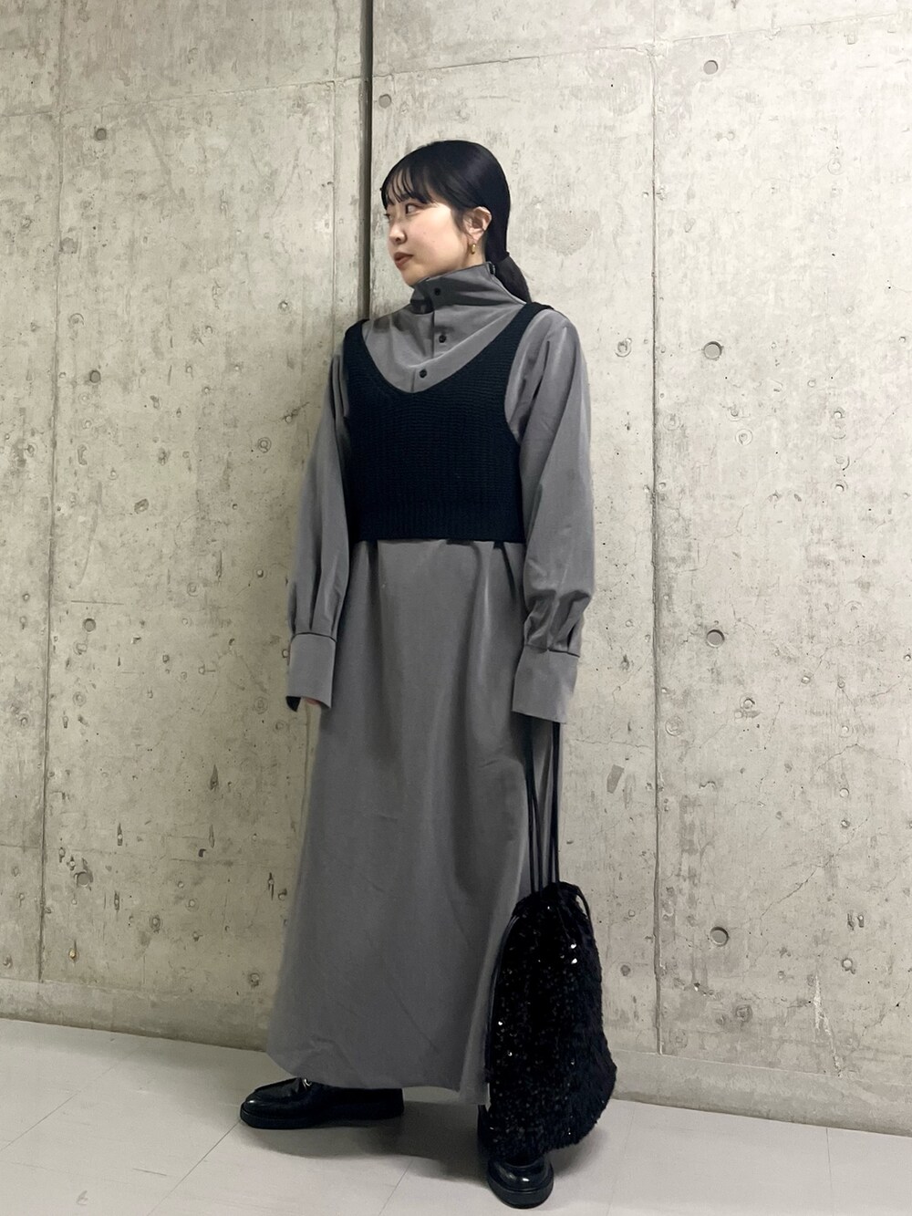 グレー系のワンピース、ブラック系のトートバッグを着用したレディースの冬コーディネートの5枚目の写真