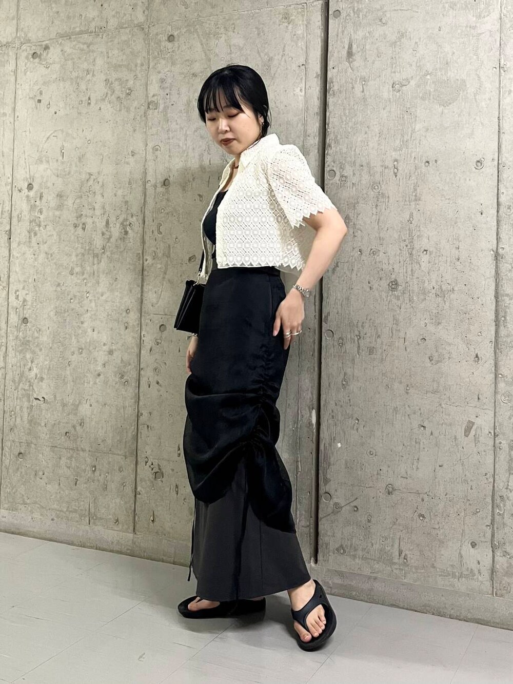 ブラック系のサンダル、ブラック系のショルダーバッグ、ブラック系のスカートを着用したレディースの夏コーディネートの4枚目の写真