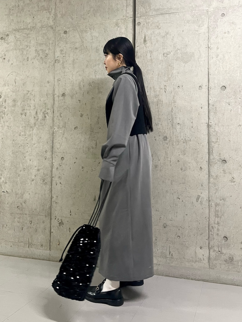 グレー系のワンピース、ブラック系のトートバッグを着用したレディースの冬コーディネートの3枚目の写真