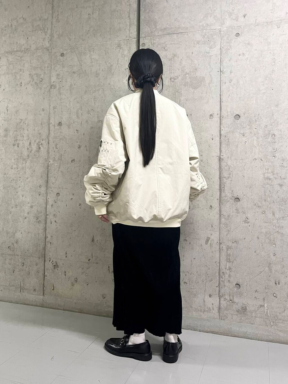 ホワイト系のMA-1、ブラック系のワンピースを着用したレディースの秋コーディネートの5枚目の写真