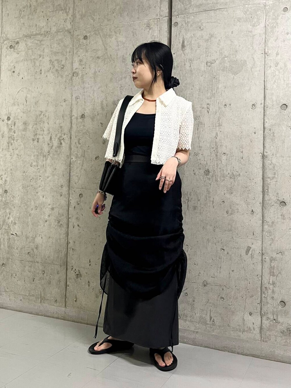 ブラック系のサンダル、ブラック系のショルダーバッグ、ブラック系のスカートを着用したレディースの夏コーディネートの2枚目の写真