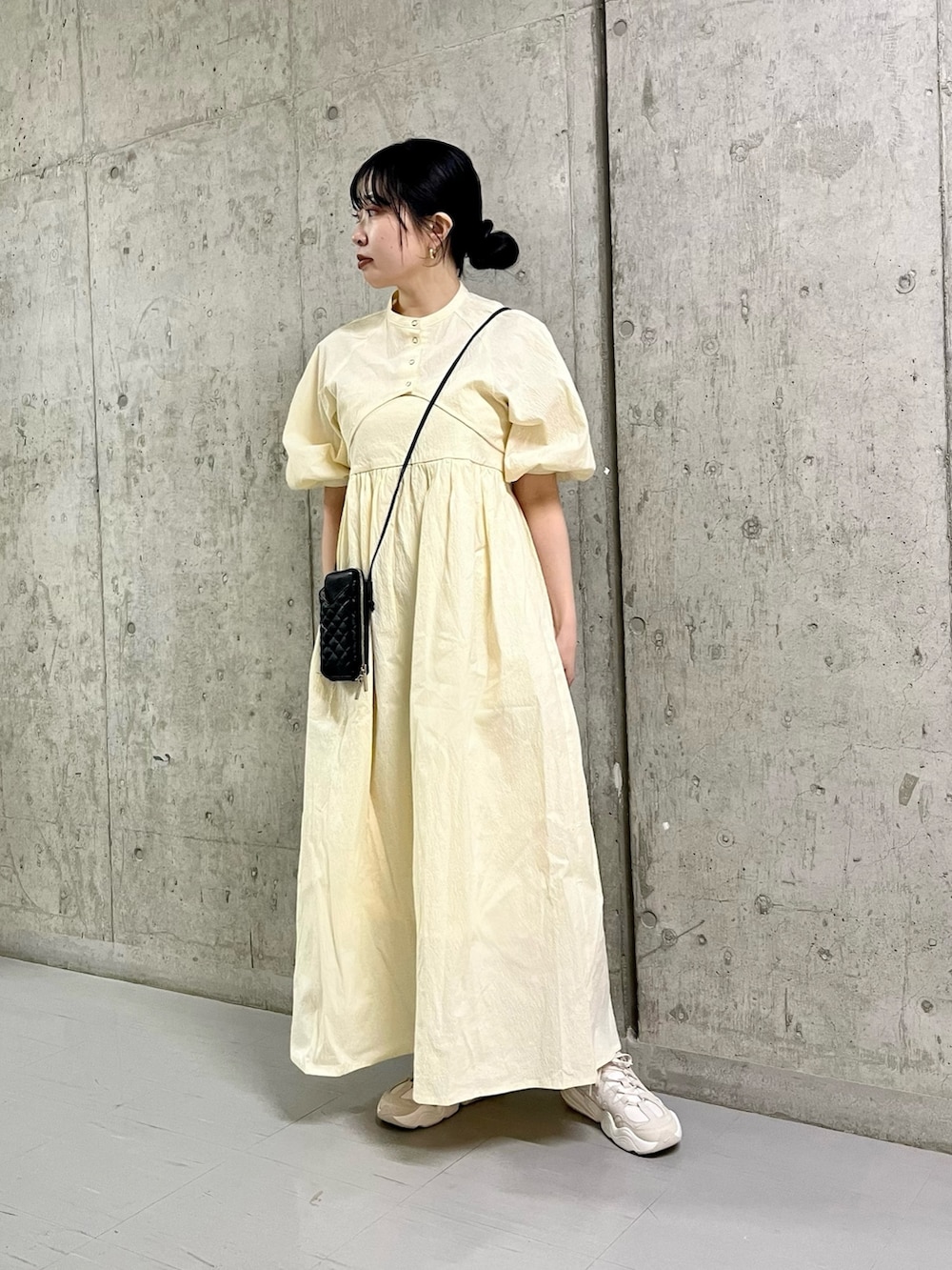 ホワイト系のワンピース、ホワイト系のスニーカー、ブラック系のショルダーバッグを着用したレディースの春コーディネートの3枚目の写真