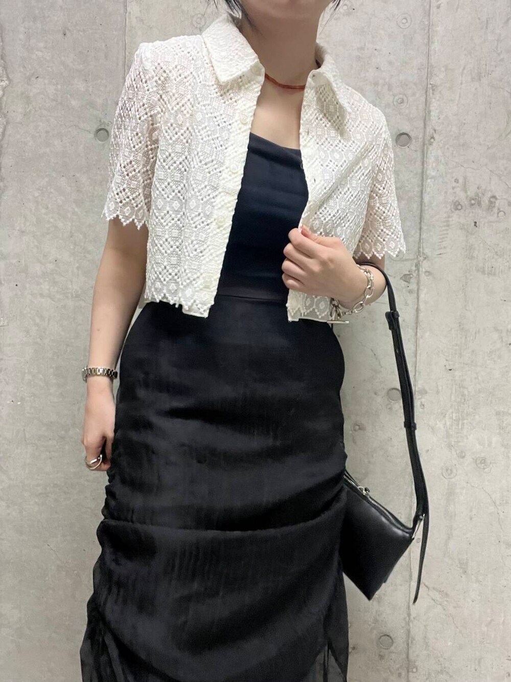 ブラック系のサンダル、ブラック系のショルダーバッグ、ブラック系のスカートを着用したレディースの夏コーディネートの3枚目の写真