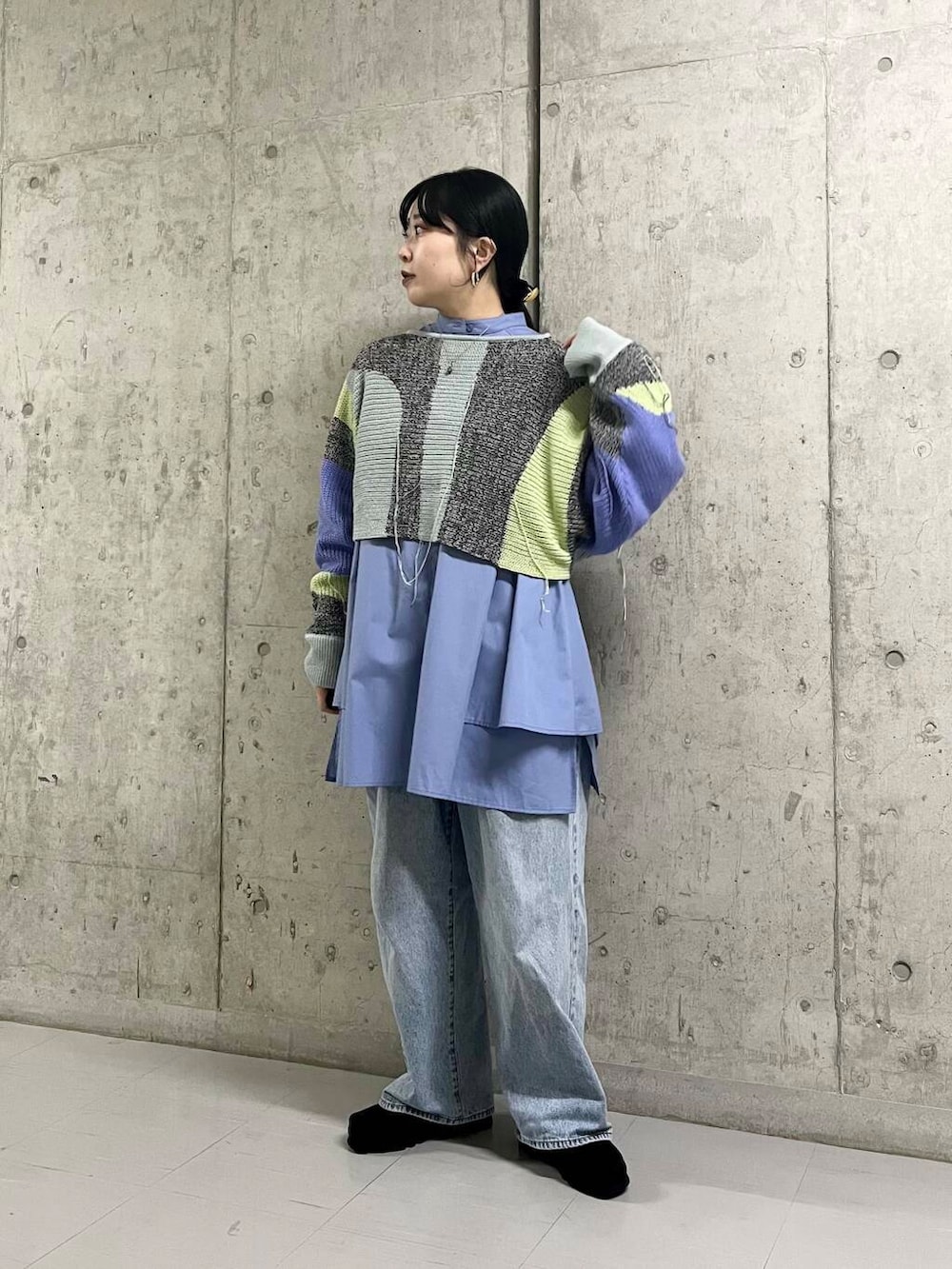 ブルー系のデニムパンツ、ブルー系のワンピース、グレー系のニット/セーターを着用したレディースの冬コーディネートの2枚目の写真