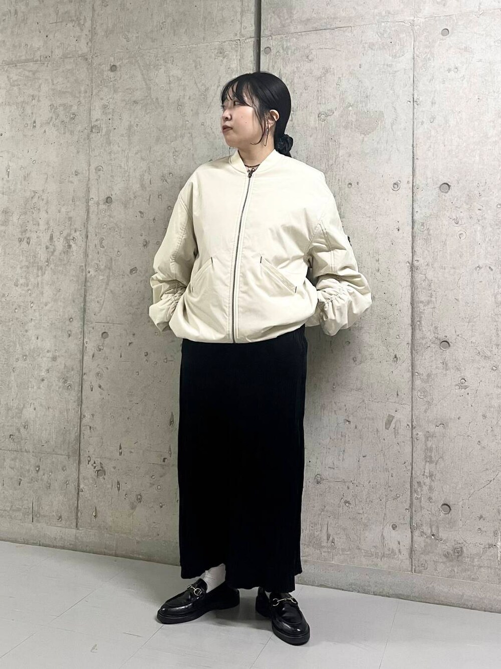 ホワイト系のMA-1、ブラック系のワンピースを着用したレディースの秋コーディネートの4枚目の写真