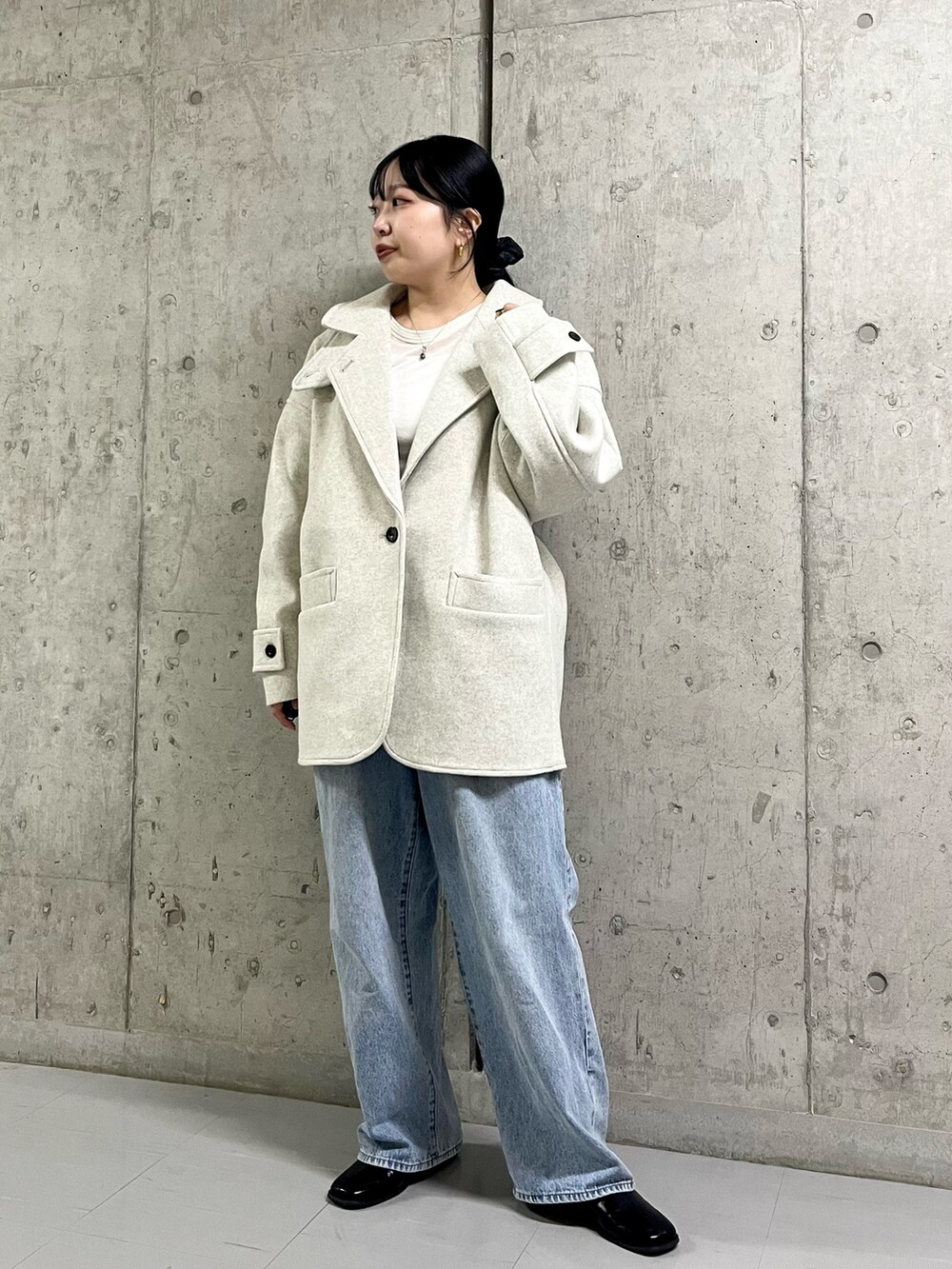 ベージュ系のステンカラーコート、ブルー系のデニムパンツ、ブラック系のその他シューズを着用したレディースの冬コーディネートの4枚目の写真