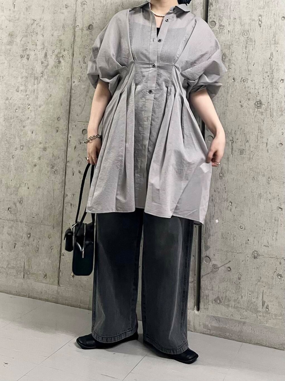 ブラック系のバレエシューズ、ブラック系のショルダーバッグ、ブラック系のデニムパンツを着用したレディースの夏コーディネートの4枚目の写真