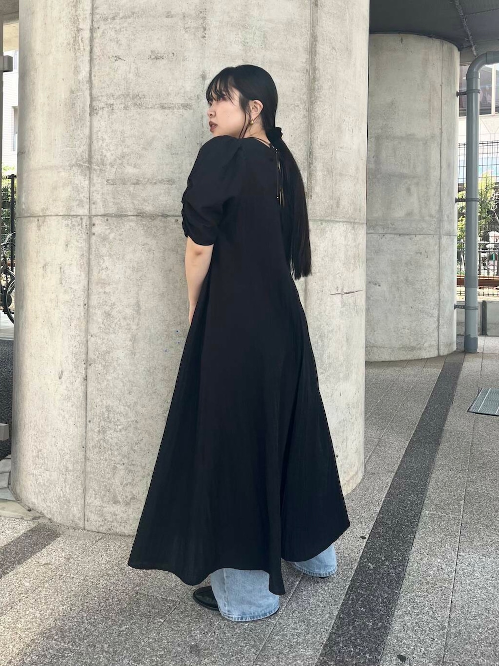 ブルー系のデニムパンツ、ベージュ系のハンドバッグ、ブラック系のバレエシューズを着用したレディースの春コーディネートの2枚目の写真