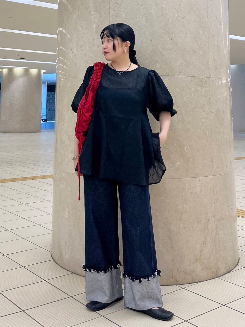 ブラック系のバレエシューズ、ブルー系のデニムパンツ、レッド系のショルダーバッグを着用したレディースの夏コーディネートの2枚目の写真