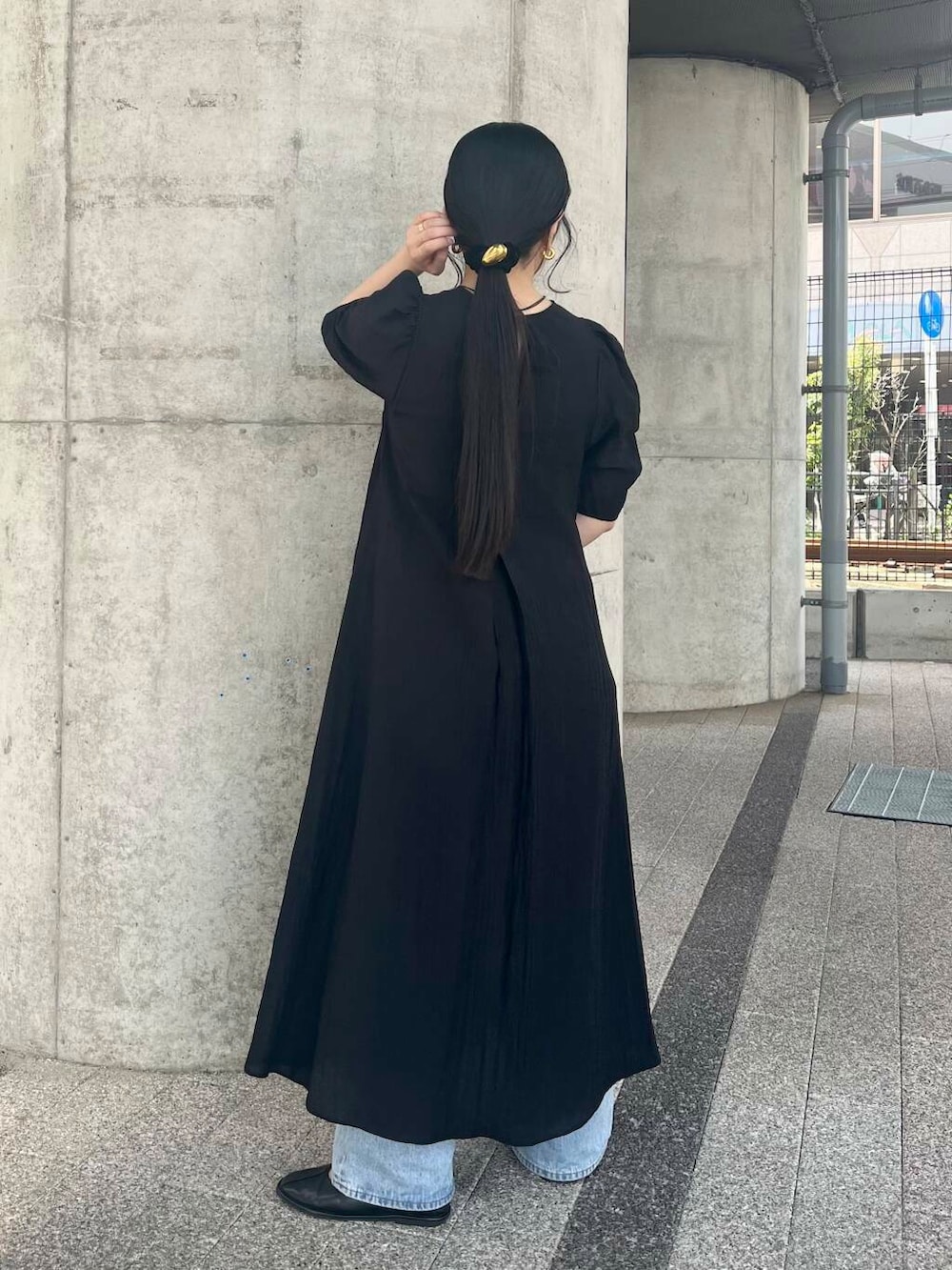 ブルー系のデニムパンツ、ベージュ系のハンドバッグ、ブラック系のバレエシューズを着用したレディースの春コーディネートの3枚目の写真