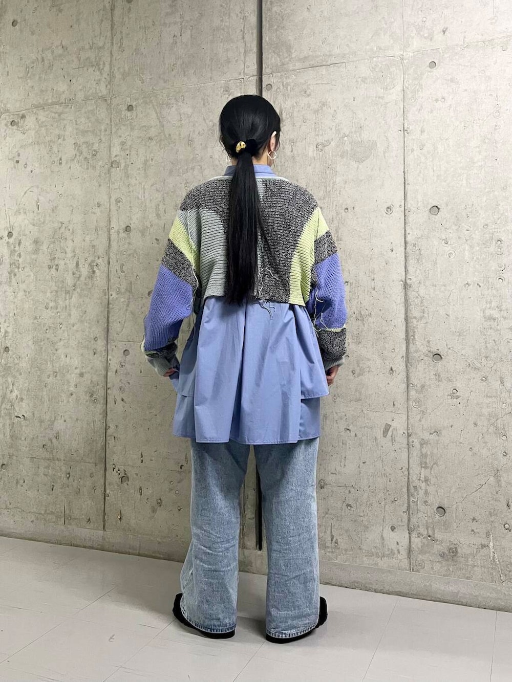 ブルー系のデニムパンツ、ブルー系のワンピース、グレー系のニット/セーターを着用したレディースの冬コーディネートの5枚目の写真