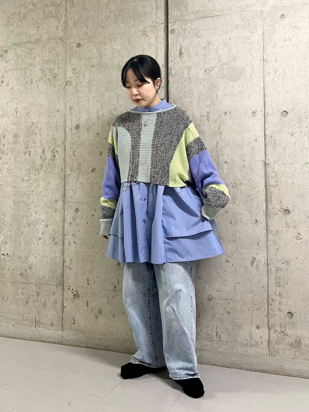 ブルー系のデニムパンツ、ブルー系のワンピース、グレー系のニット/セーターを着用したレディースの冬コーディネートの3枚目の写真