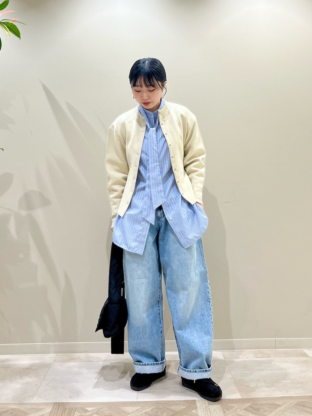 ベージュ系のカーディガン/ボレロ、ブルー系のシャツ/ブラウス、ブルー系のデニムパンツを着用したレディースの冬コーディネートの2枚目の写真