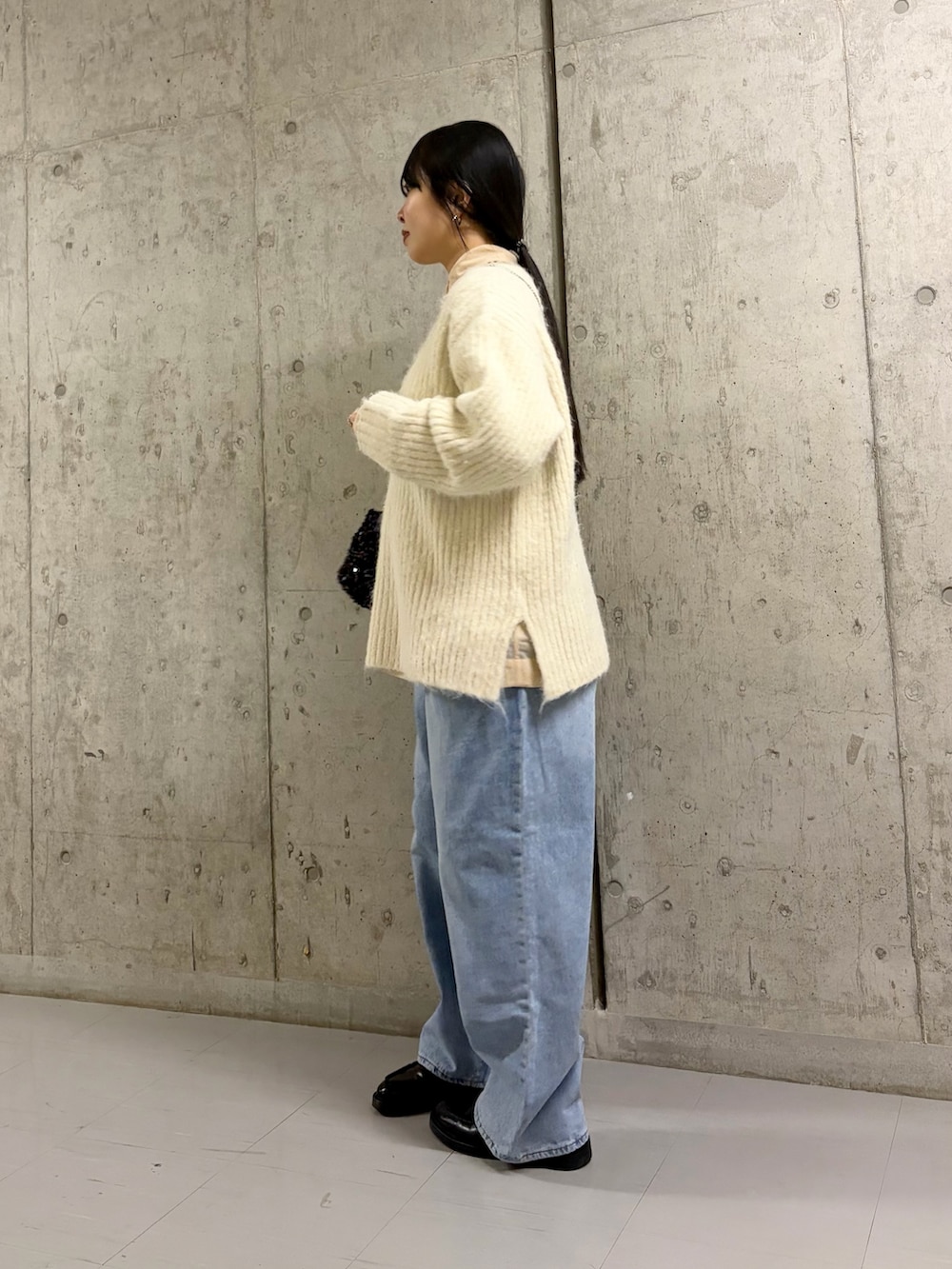 ホワイト系のニット/セーター、ベージュ系のシャツ/ブラウス、ブラック系のショルダーバッグを着用したレディースの冬コーディネートの3枚目の写真