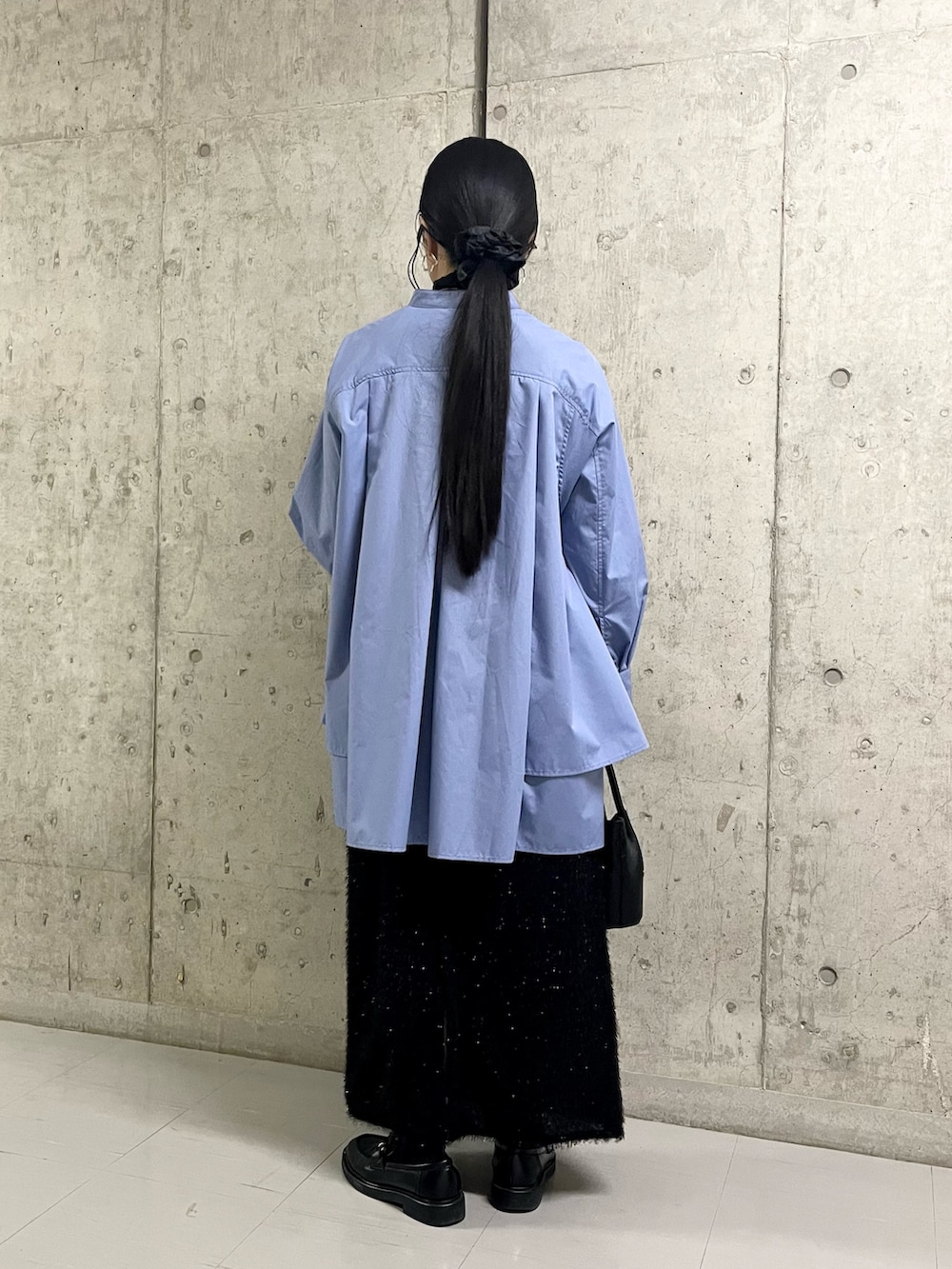 ブルー系のワンピース、ブラック系のスカート、ブラック系のショルダーバッグを着用したレディースの冬コーディネートの4枚目の写真