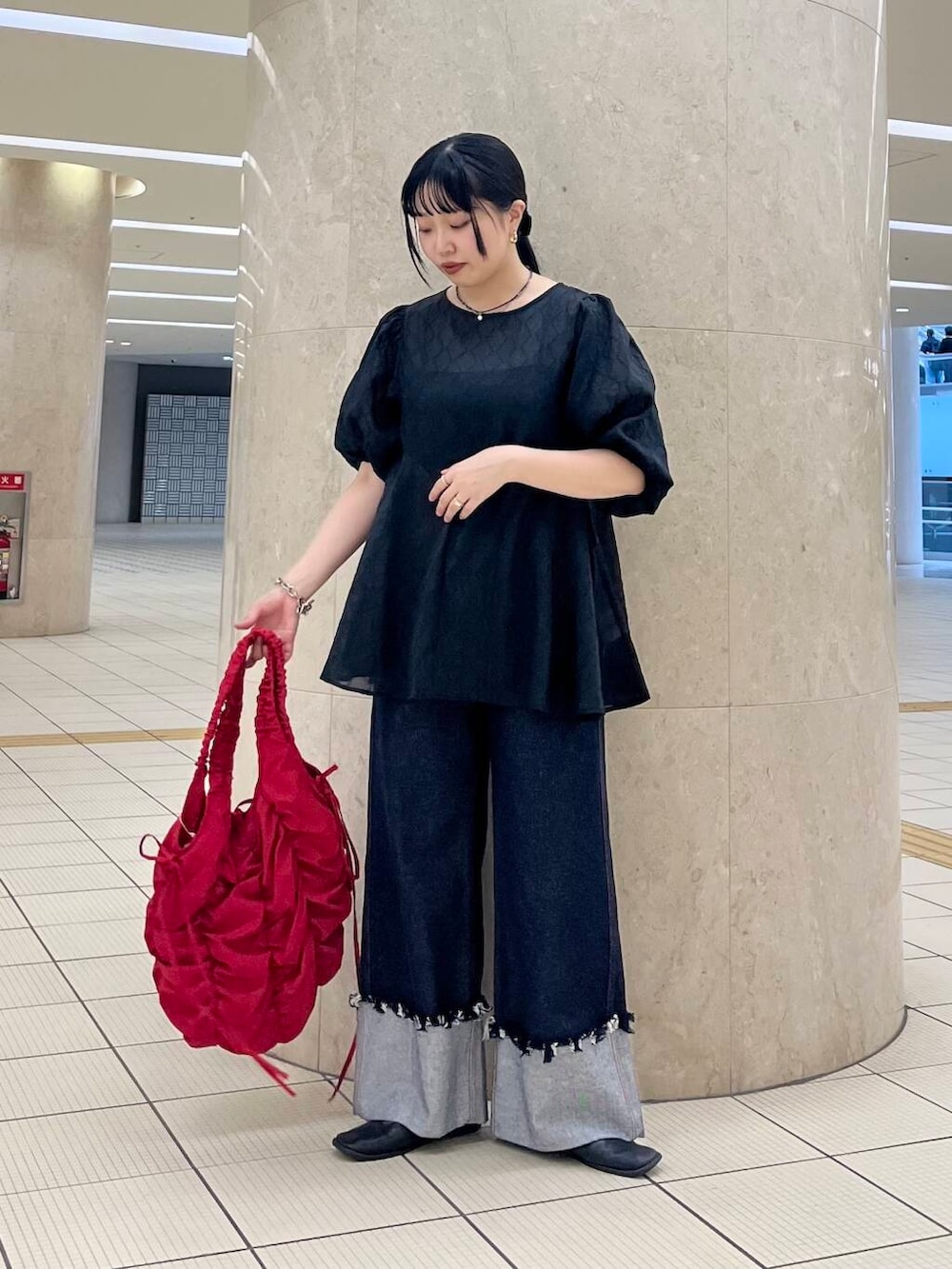 ブラック系のバレエシューズ、ブルー系のデニムパンツ、レッド系のショルダーバッグを着用したレディースの夏コーディネートの6枚目の写真