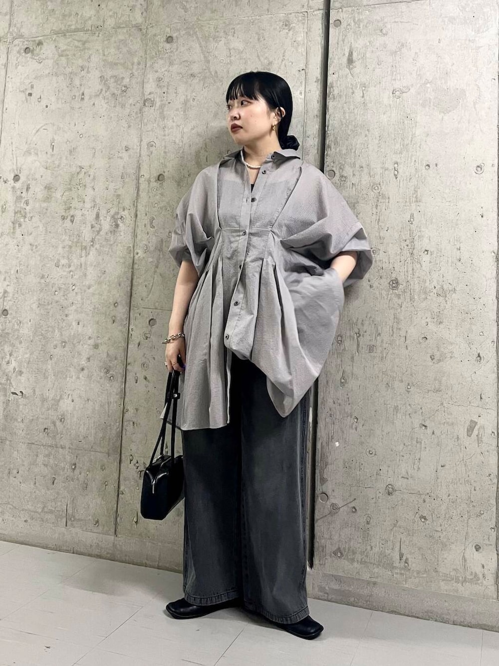 ブラック系のバレエシューズ、ブラック系のショルダーバッグ、ブラック系のデニムパンツを着用したレディースの夏コーディネートの3枚目の写真