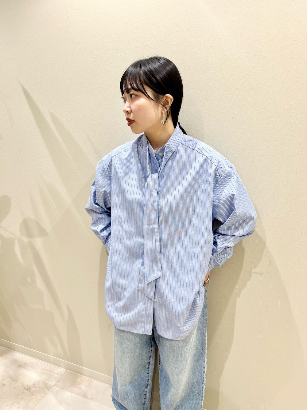 ベージュ系のカーディガン/ボレロ、ブルー系のシャツ/ブラウス、ブルー系のデニムパンツを着用したレディースの冬コーディネートの3枚目の写真