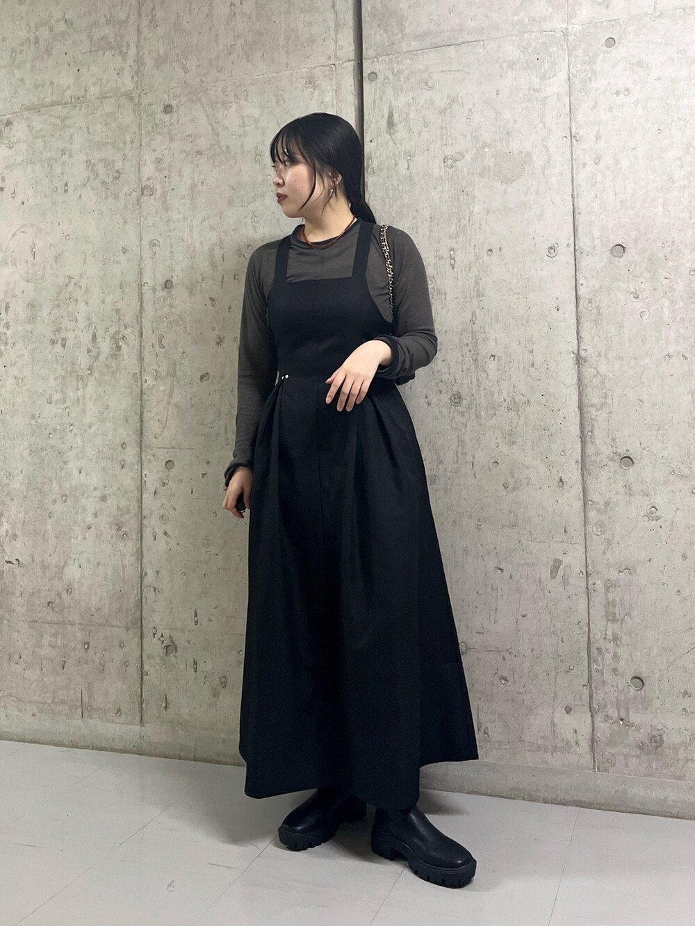 グレー系のTシャツ/カットソー、ブラック系のショルダーバッグ、ブラック系のブーツを着用したレディースの秋コーディネートの2枚目の写真