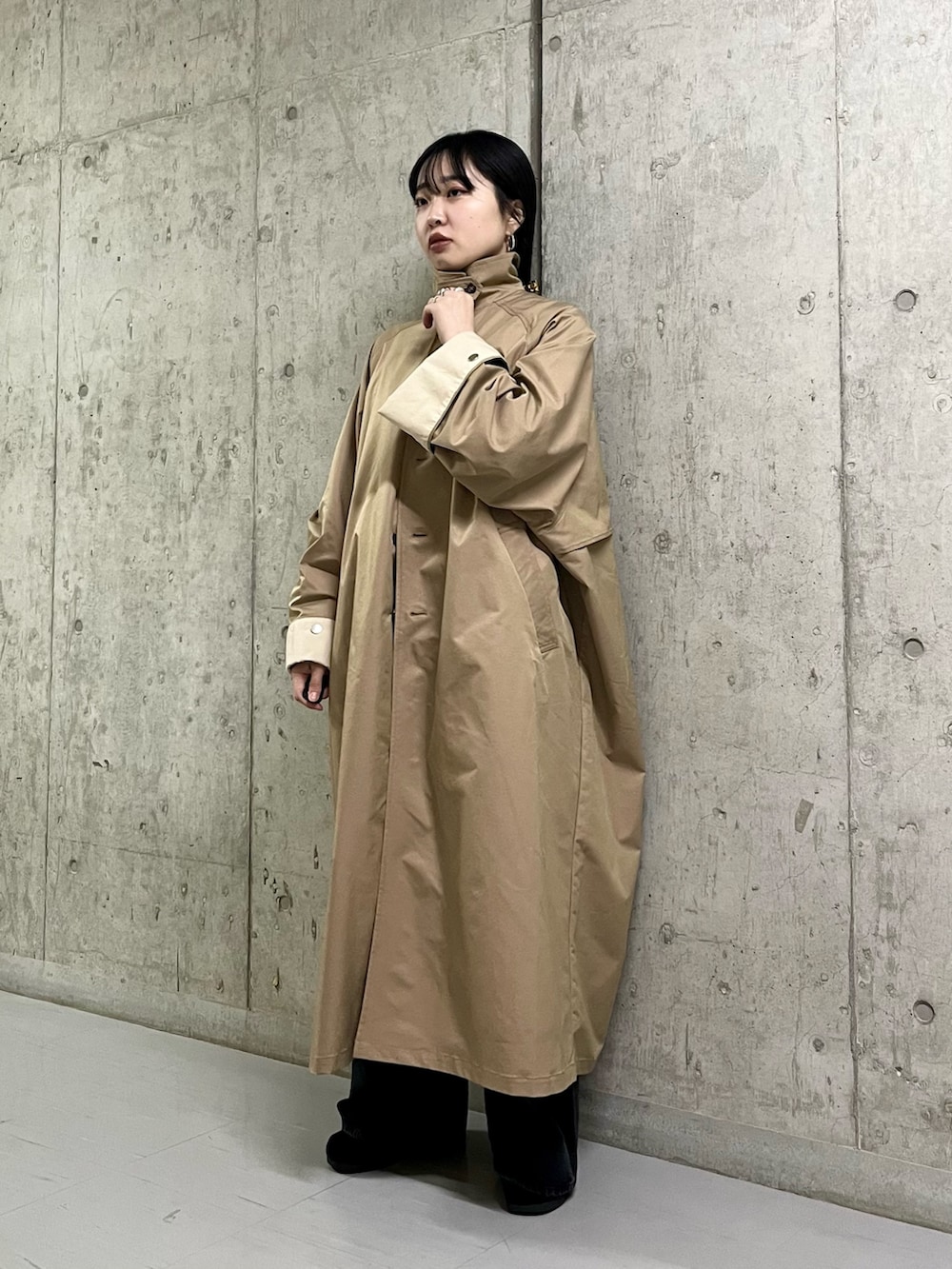 ベージュ系のステンカラーコート、ブラック系のサロペット/オーバーオール、ブラック系のその他シューズを着用したレディースの春コーディネートの5枚目の写真