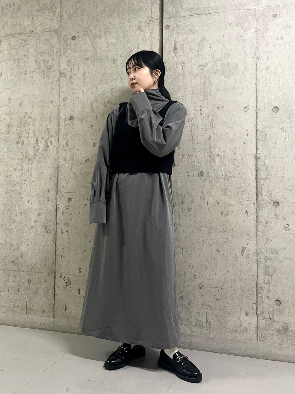 グレー系のワンピース、ブラック系のトートバッグを着用したレディースの冬コーディネートの2枚目の写真