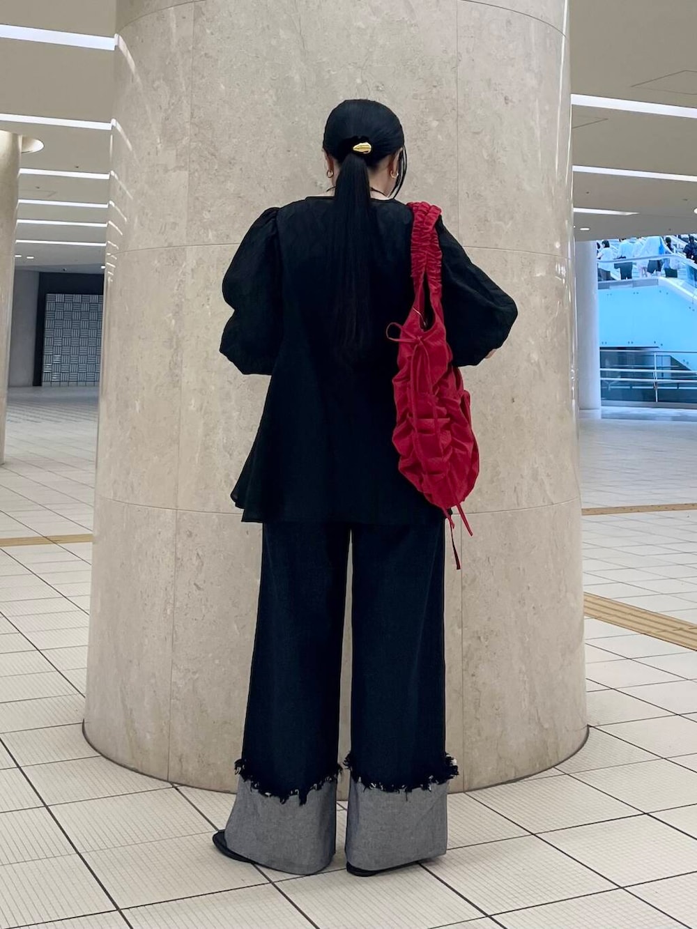 ブラック系のバレエシューズ、ブルー系のデニムパンツ、レッド系のショルダーバッグを着用したレディースの夏コーディネートの4枚目の写真