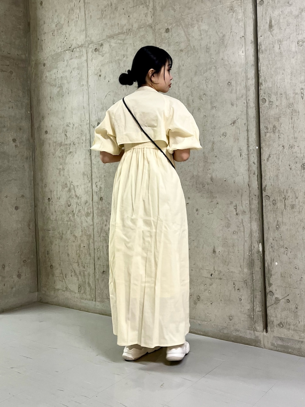 ホワイト系のワンピース、ホワイト系のスニーカー、ブラック系のショルダーバッグを着用したレディースの春コーディネートの5枚目の写真