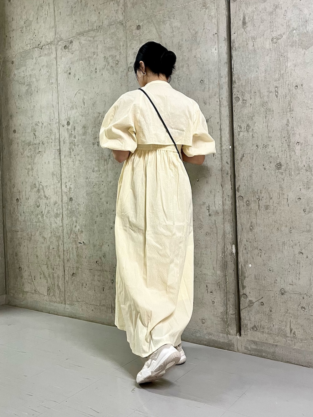 ホワイト系のワンピース、ホワイト系のスニーカー、ブラック系のショルダーバッグを着用したレディースの春コーディネートの4枚目の写真