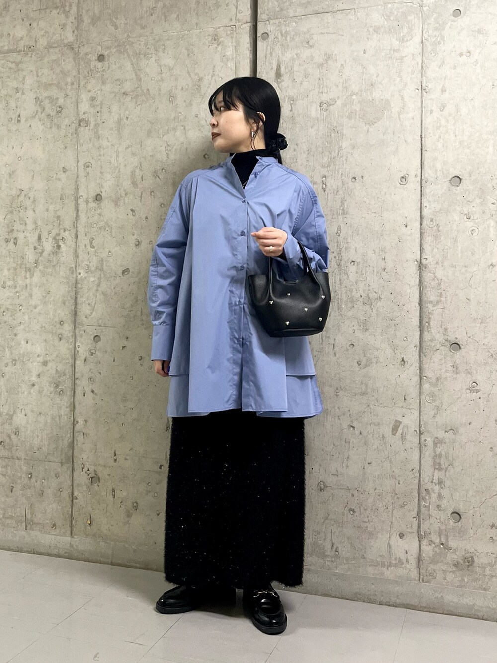 ブルー系のワンピース、ブラック系のスカート、ブラック系のショルダーバッグを着用したレディースの冬コーディネートの3枚目の写真