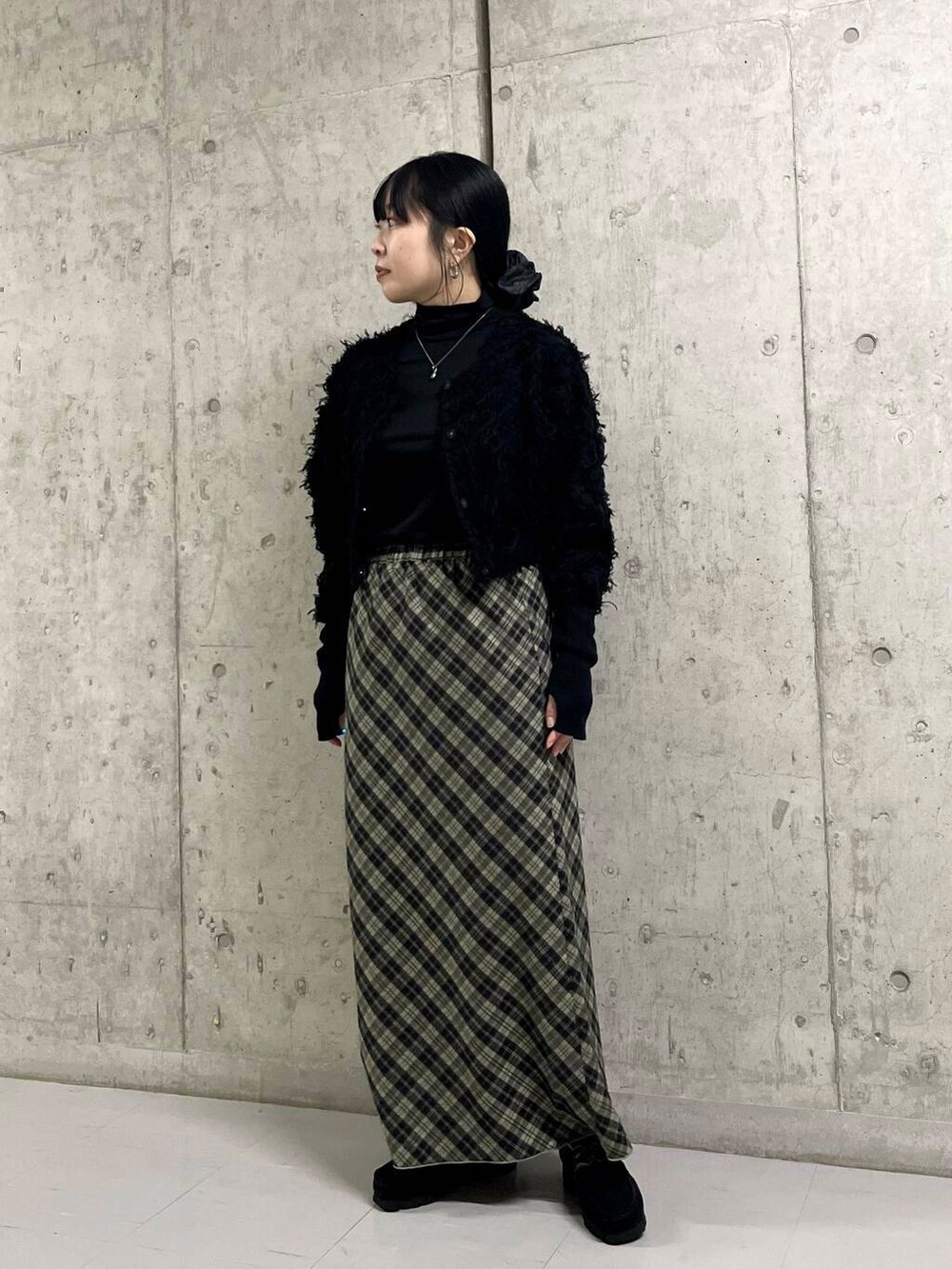 ブルー系のステンカラーコート、ブラック系のカーディガン/ボレロ、グリーン系のスカートを着用したレディースの冬コーディネートの6枚目の写真