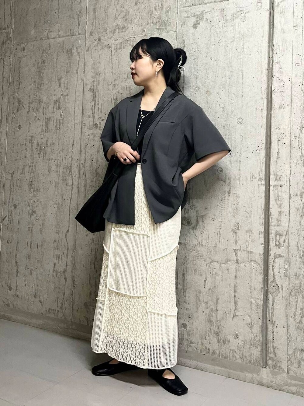 ブラック系のバレエシューズ、ブラック系のショルダーバッグ、グレー系のその他アウターを着用したレディースの春コーディネートの2枚目の写真