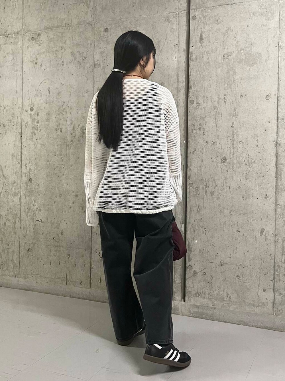 ブラック系のデニムパンツ、レッド系のハンドバッグ、ホワイト系のTシャツ/カットソーを着用したレディースの夏コーディネートの5枚目の写真