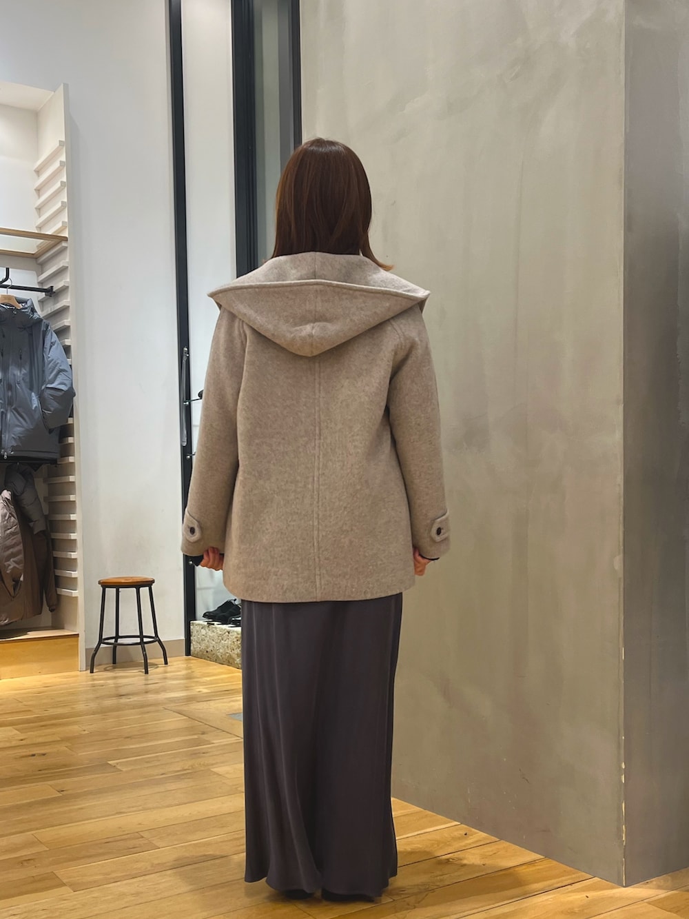 グレー系のスカート、ブルー系のニット/セーター、ベージュ系のその他アウターを着用したレディースの秋コーディネートの3枚目の写真