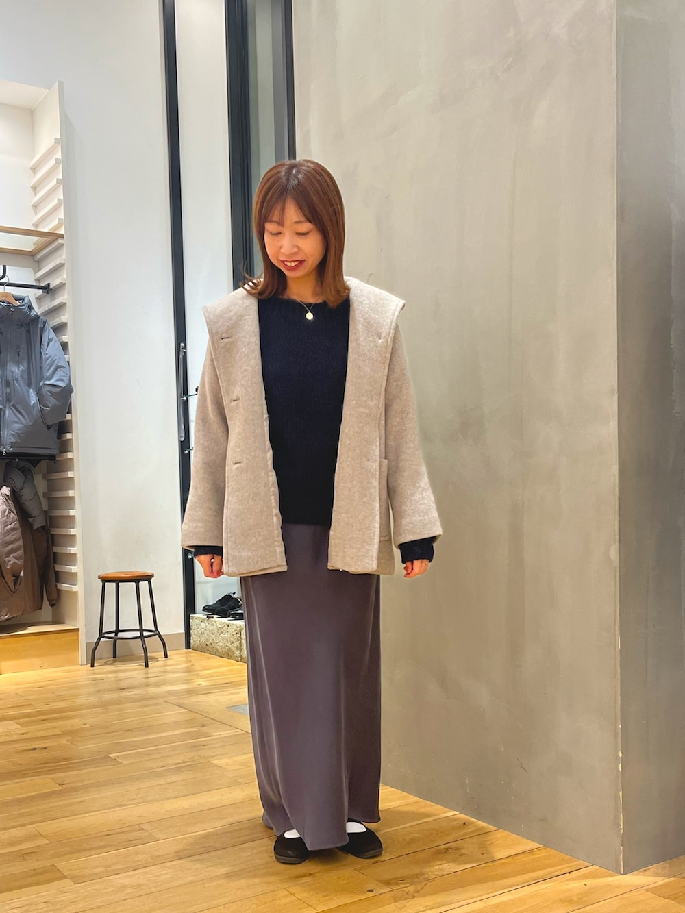 グレー系のスカート、ブルー系のニット/セーター、ベージュ系のその他アウターを着用したレディースの秋コーディネートの2枚目の写真