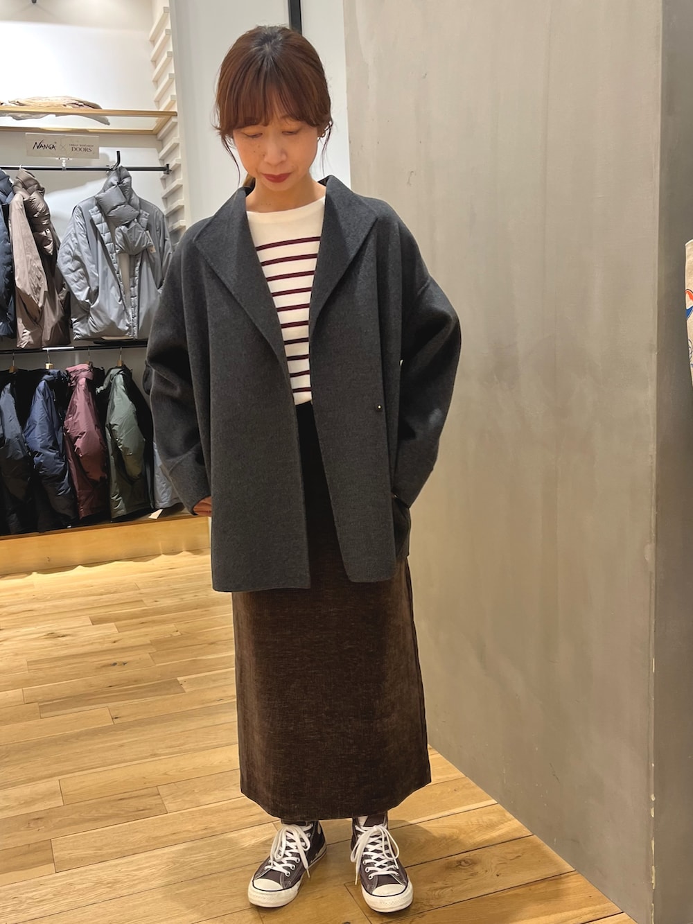 グレー系のその他アウター、レッド系のニット/セーター、ブラウン系のスカートを着用したレディースの秋コーディネートの2枚目の写真